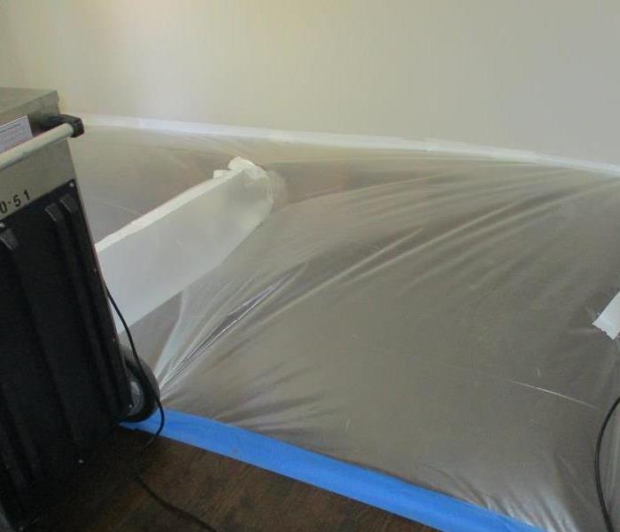 SERVPRO built a tent with 3 mil plastic that covers wet hardwood floors and affected wall cavity. 