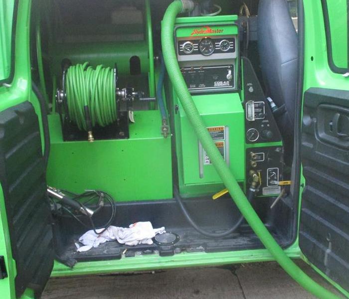 inside of green van with green equipment, cords and hoses